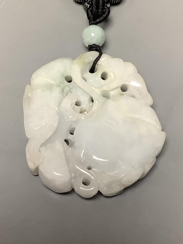 A Chinese pale grey jade carved and pierced pendant depicting two monkeys on a loquat, W 5cm